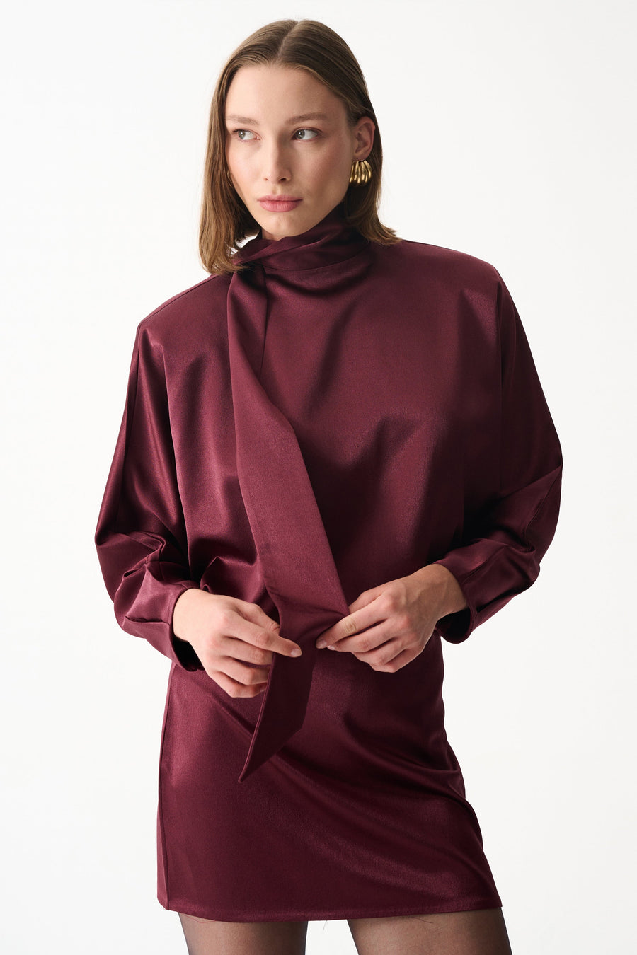 Burgundy satin mini dress with long sleeves, high neck, and draped scarf detail